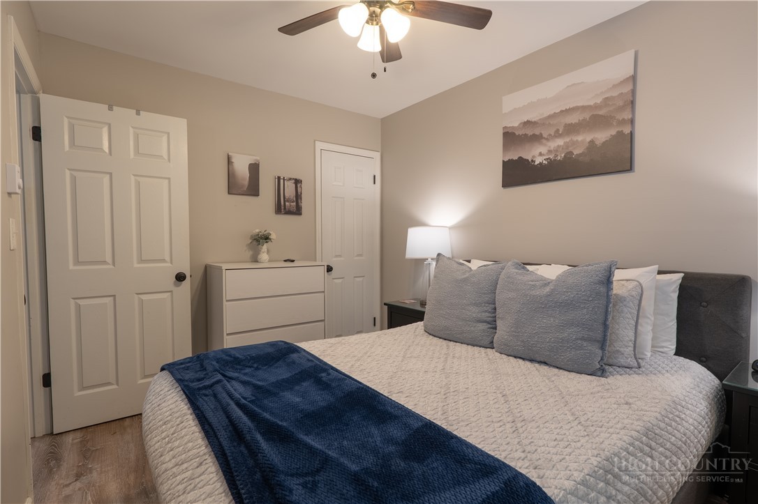 141 Snowflake Road Banner Elk, NC 28604 - Photo 10 of 28 a bedroom with a bed and a chandelier
