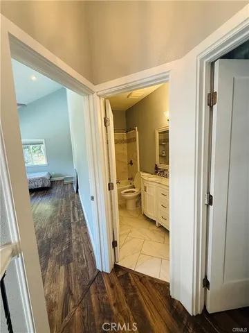 a view of a hallway with wooden floor and bedroom