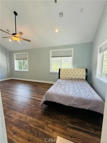 a bedroom with a bed ceiling fan and window