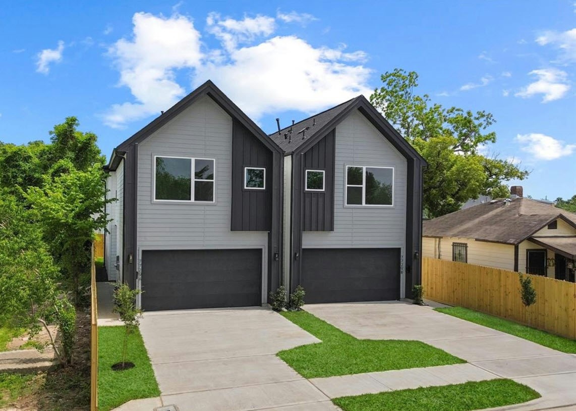 a front view of house with yard and trees in the background