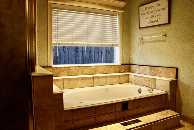 a bathroom with a bathtub and next to a window