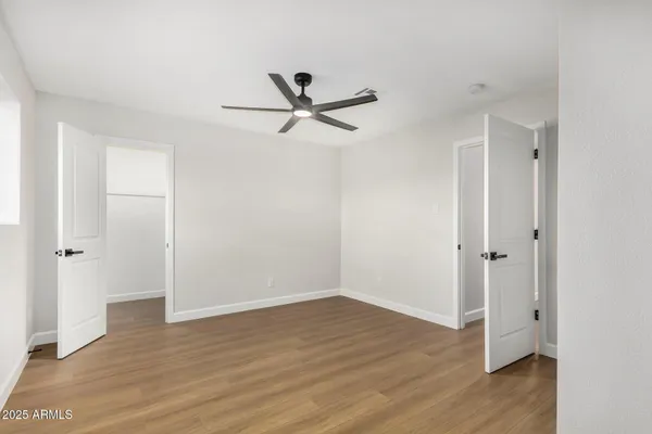 a view of a room with wooden floor and ceiling fan