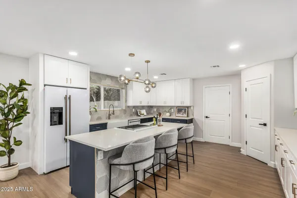 a kitchen with refrigerator and chairs
