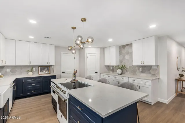 a kitchen with stainless steel appliances granite countertop a sink a stove and a refrigerator