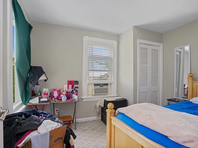 a bedroom with a bed and two window