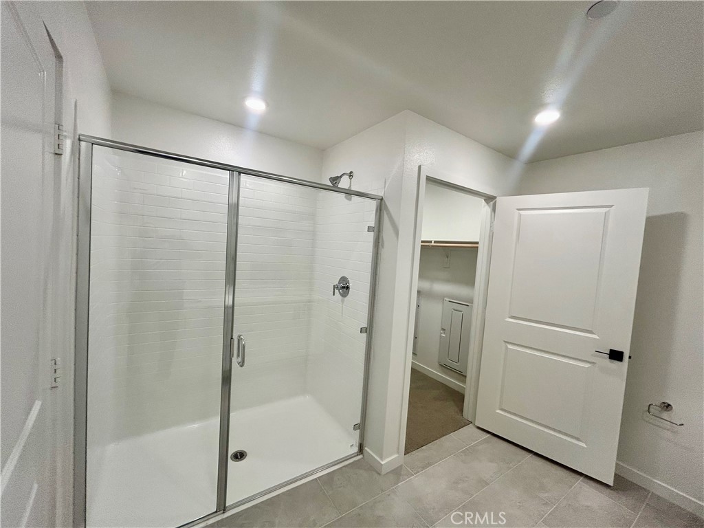 6114 Valentina Way, Unit 101 Eastvale, CA 92880 - Photo 11 of 23 a bathroom with a glass shower door