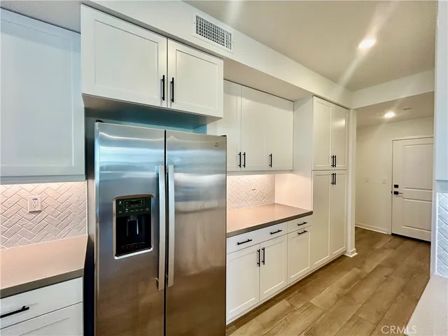 a kitchen with stainless steel appliances kitchen island a refrigerator sink and cabinets
