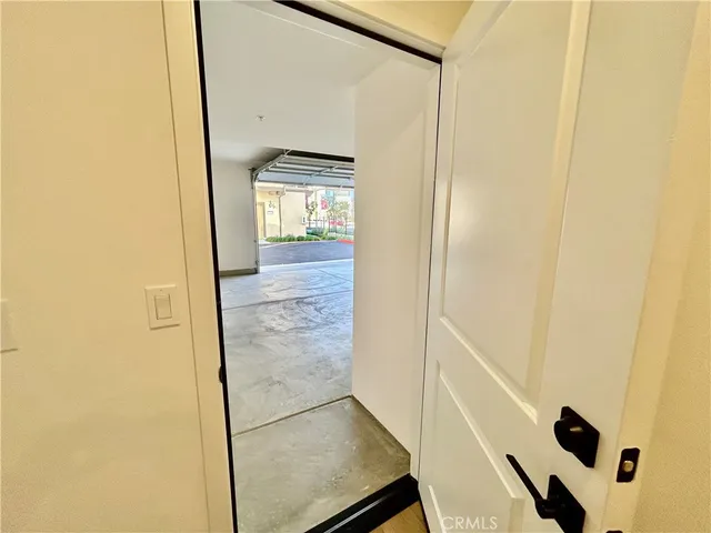 a view of a hallway with wooden floor and a bathroom