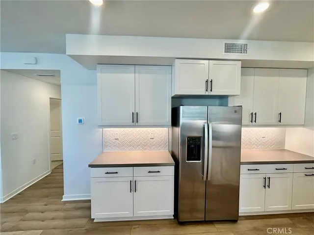 a kitchen with stainless steel appliances granite countertop a refrigerator and a stove