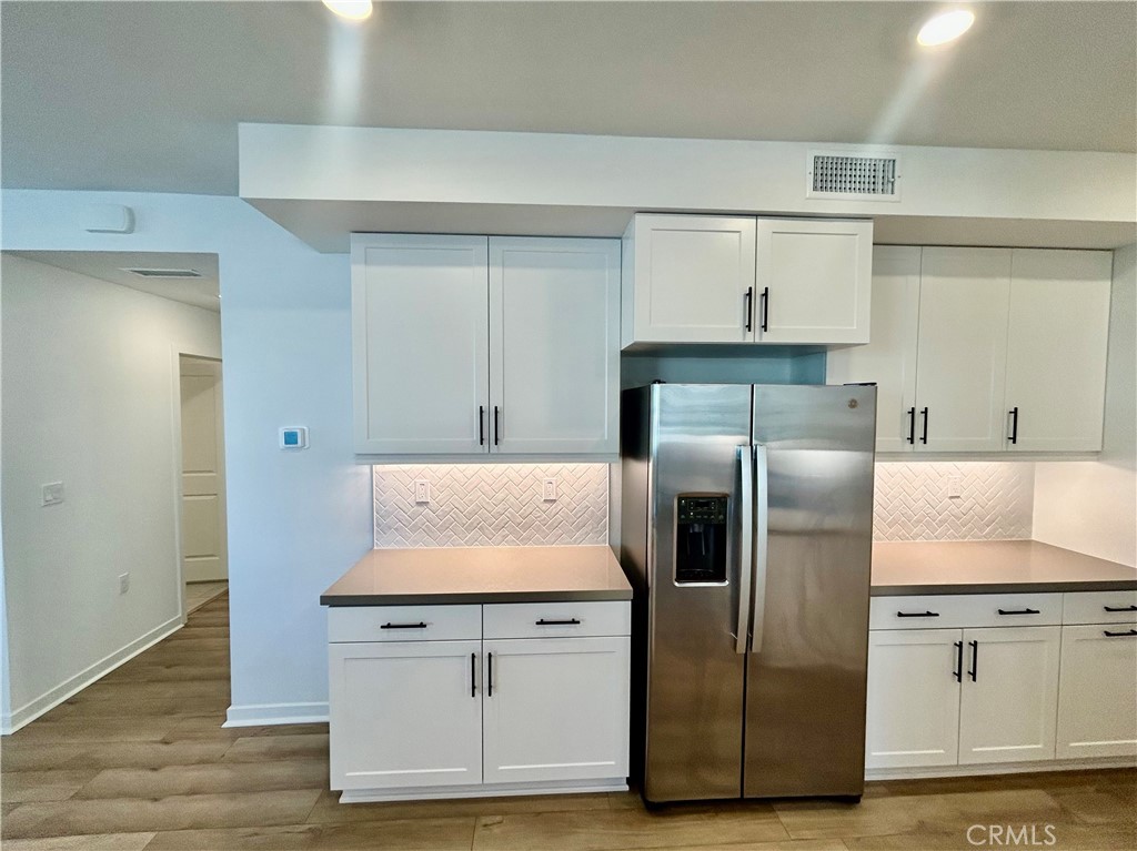 6114 Valentina Way, Unit 101 Eastvale, CA 92880 - Photo 7 of 23 a kitchen with stainless steel appliances granite countertop a refrigerator and a stove