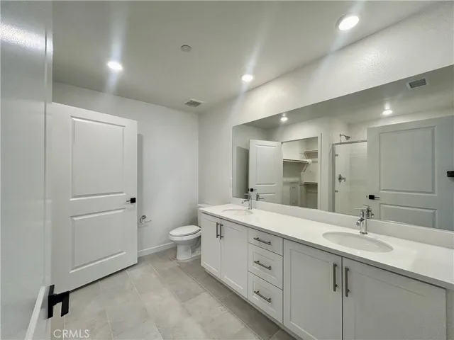a spacious bathroom with a double vanity sink mirror and toilet