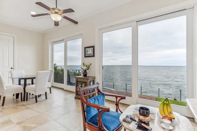 a kitchen with stainless steel appliances kitchen island granite countertop a refrigerator a stove a oven and white cabinets with wooden floor