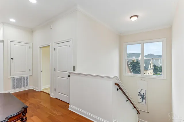 a kitchen with granite countertop a stove a sink and white cabinets with wooden floor