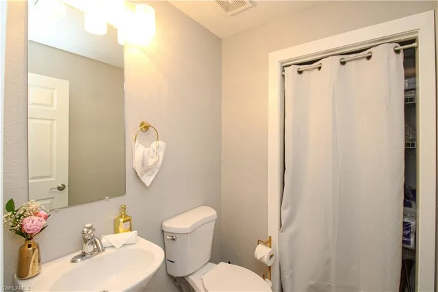a white toilet sitting next to a bathroom sink