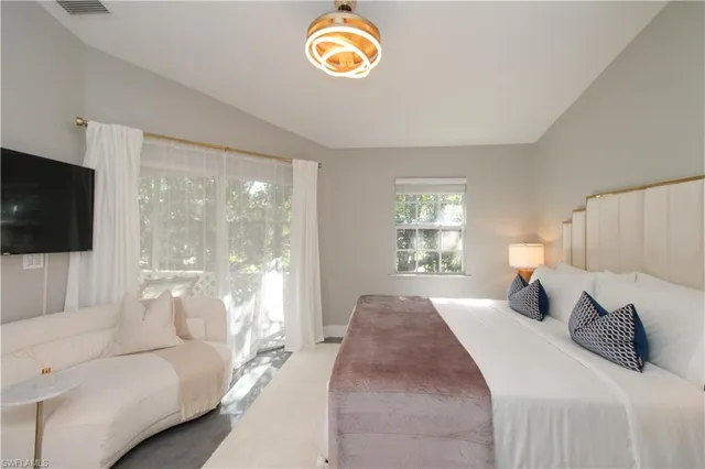 a bedroom with a bed and a large window