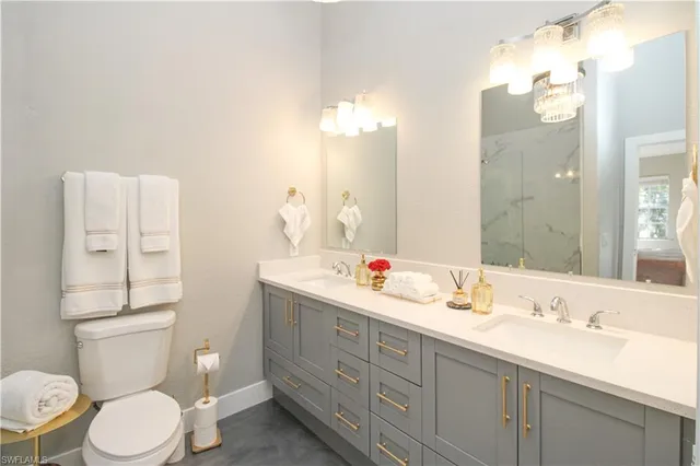 a bathroom with a double vanity sink mirror and toilet