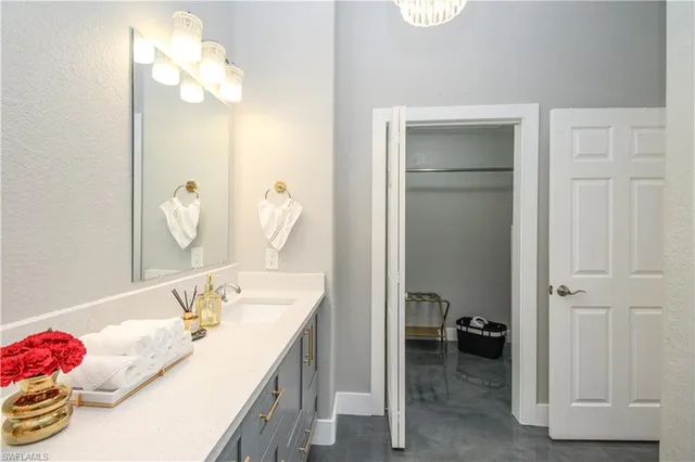 a en suite bathroom with a granite countertop sink and a mirror