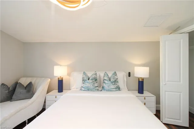 a spacious bedroom with a bed and lamp