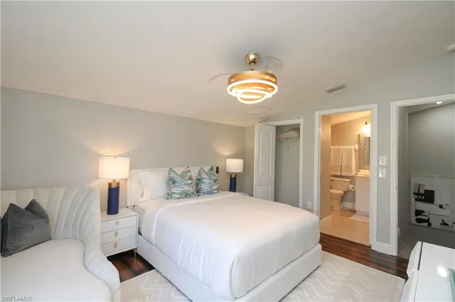 a bedroom with a bed and painting on the wall