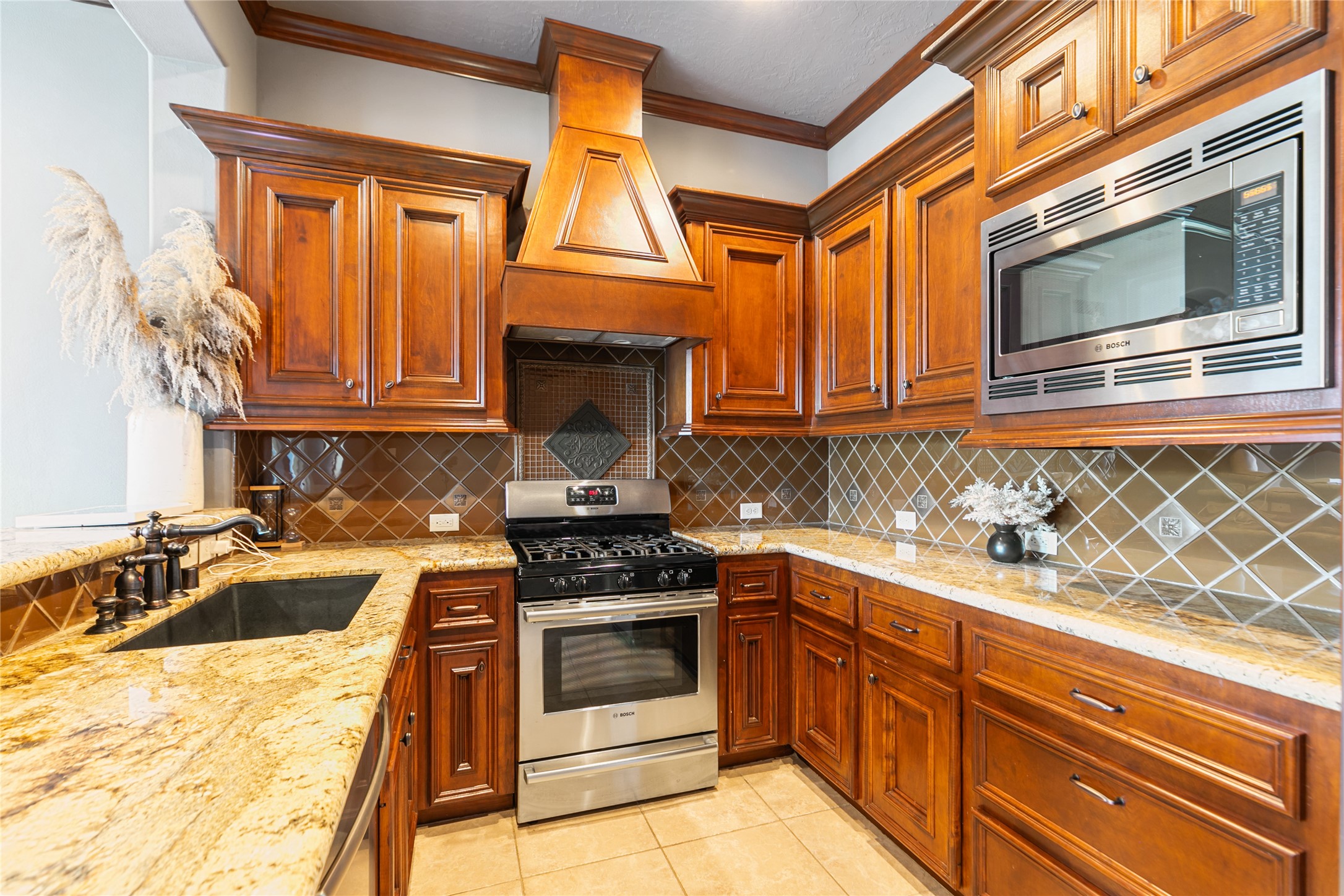 22 Post Shadow Estate Drive Spring, TX 77389 - Photo 49 of 50 a kitchen with granite countertop a stove top oven microwave and cabinets