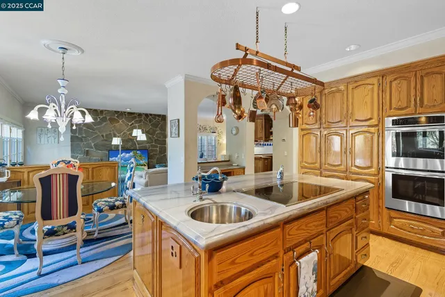 a kitchen with stainless steel appliances granite countertop a sink a stove and a refrigerator