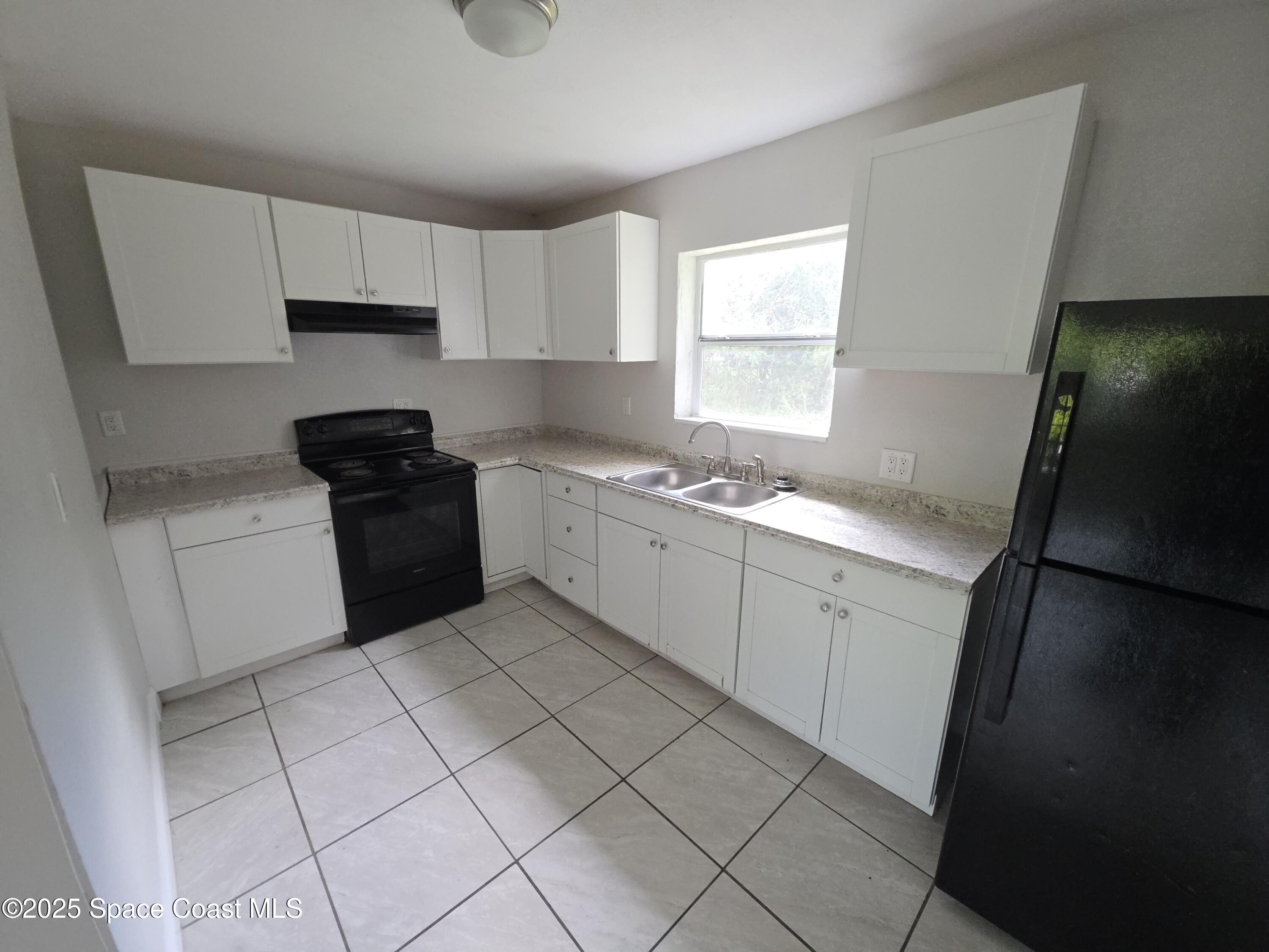 413 Dove Avenue Rockledge, FL 32955 - Photo 4 of 10 a kitchen with a sink a stove and cabinets