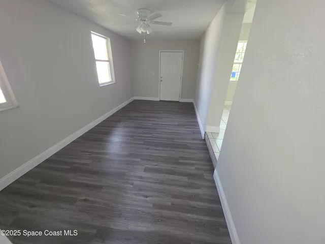 a view of a hallway with wooden floor and staircase