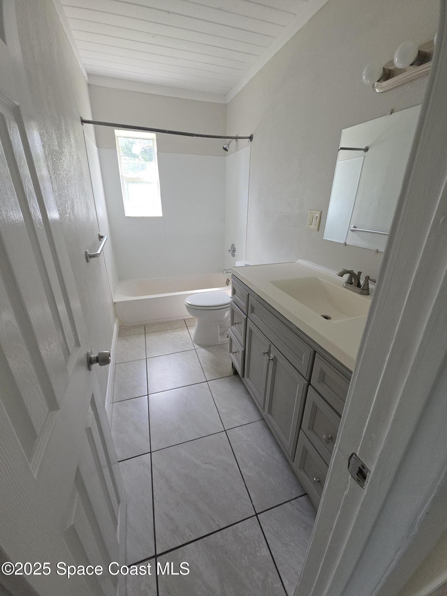 413 Dove Avenue Rockledge, FL 32955 - Photo 7 of 10 a bathroom with a sink a toilet and shower