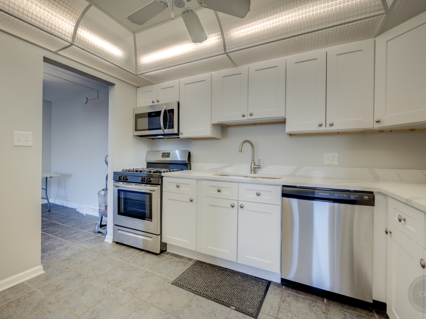 100 West Butterfield Road, Unit 405N Elmhurst, IL 60126 - Photo 7 of 27 a kitchen with granite countertop white cabinets sink and stainless steel appliances
