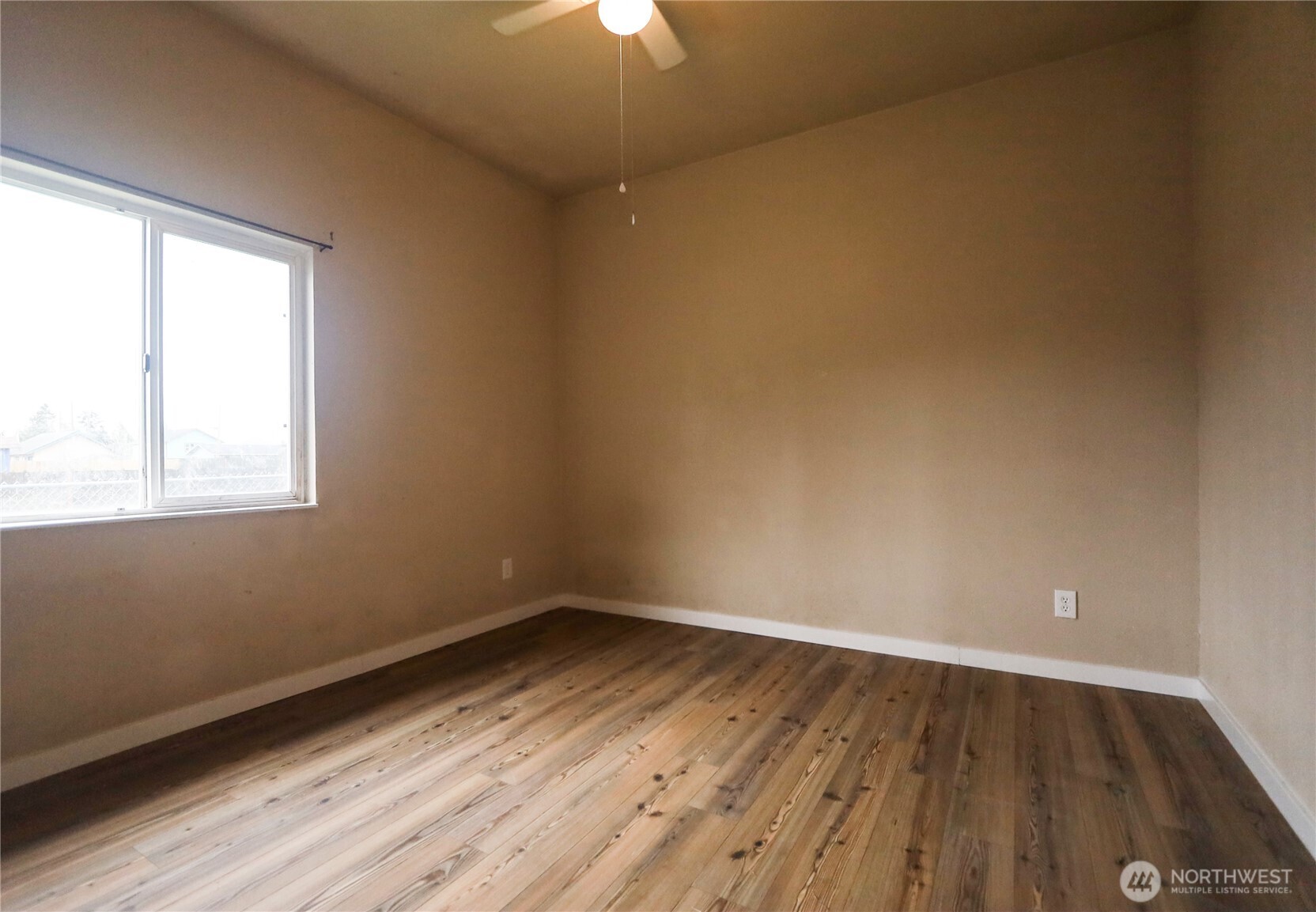 912 Ramer Avenue Hoquiam, WA 98550 - Photo 11 of 20 a view of a room with wooden floor and windows