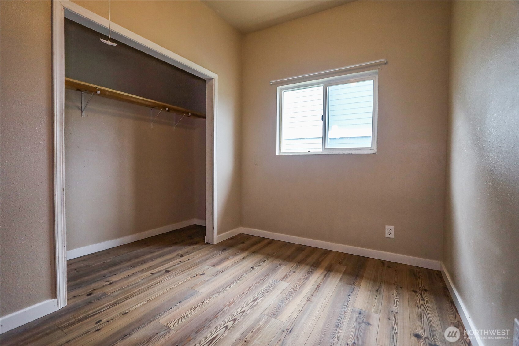 912 Ramer Avenue Hoquiam, WA 98550 - Photo 13 of 20 a view of an empty room with wooden floor and a window