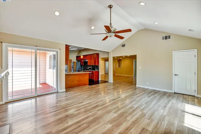 an empty room with windows a fireplace and wooden floor