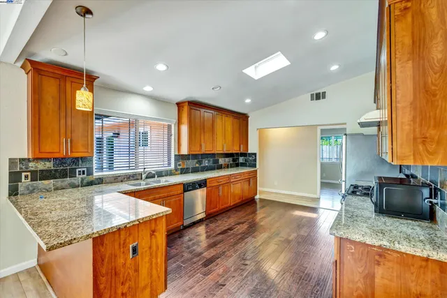 a kitchen with stainless steel appliances a refrigerator sink and stove