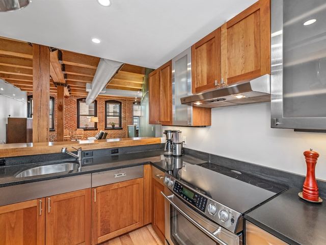 a kitchen with granite countertop a sink stove and cabinets