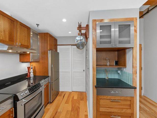 a kitchen with stainless steel appliances granite countertop a refrigerator and a sink