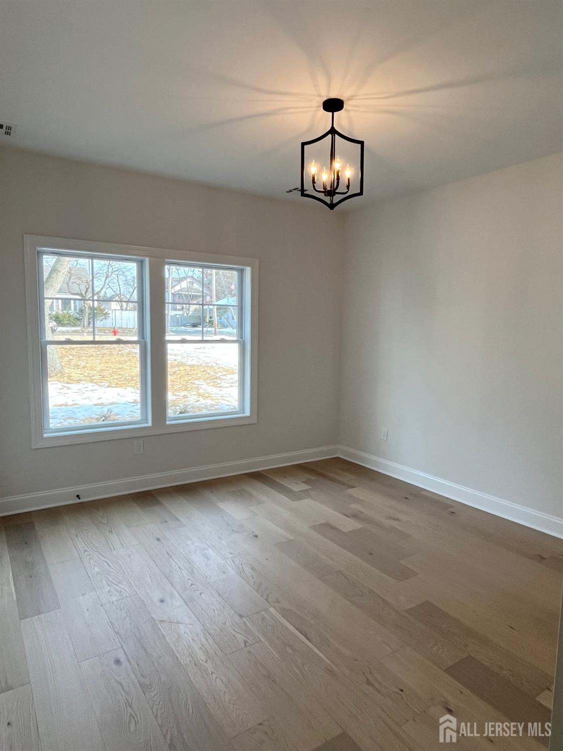 10 Johnson Avenue Matawan, NJ 07747 - Photo 11 of 26 an empty room with wooden floor cabinet and windows