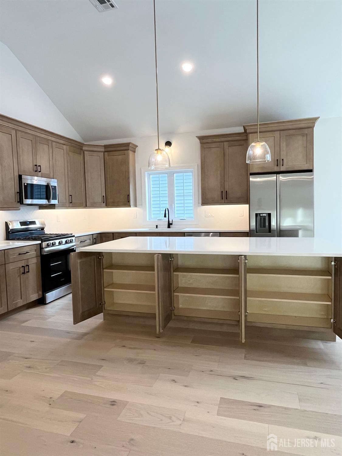 10 Johnson Avenue Matawan, NJ 07747 - Photo 4 of 26 a kitchen with kitchen island white cabinets and stainless steel appliances