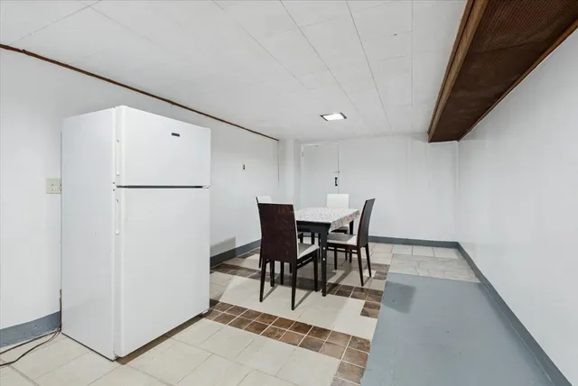 a view of a dining room with furniture and a refrigerator
