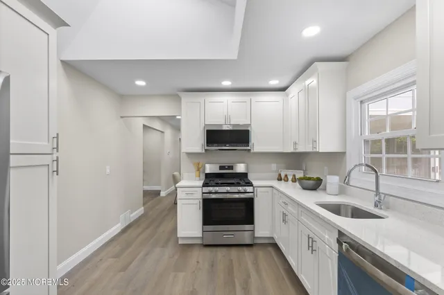 a kitchen with sink a microwave and cabinets