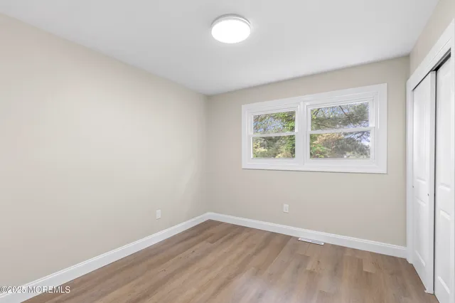 a view of a hallway with wooden floor and furniture