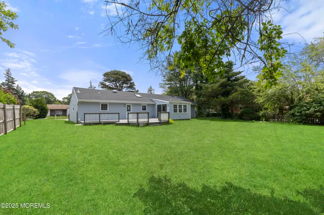 a view of a house with a big yard and large trees