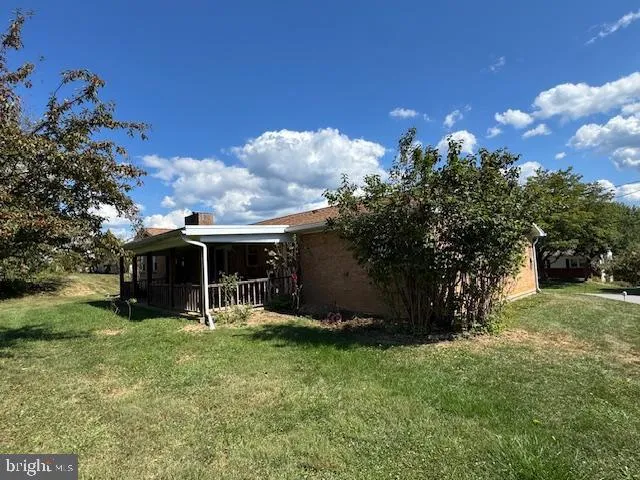 a view of a house with backyard and a tree