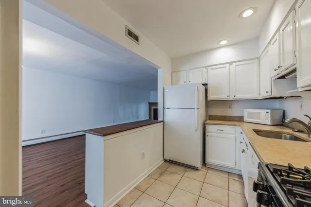 a view of a room with wooden floor and kitchen