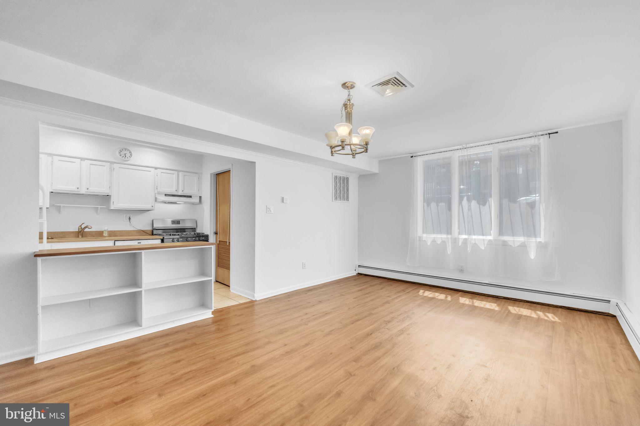 1928 Rodman Street, Unit A Philadelphia, PA 19146 - Photo 12 of 28 a view of a room with wooden floor and kitchen