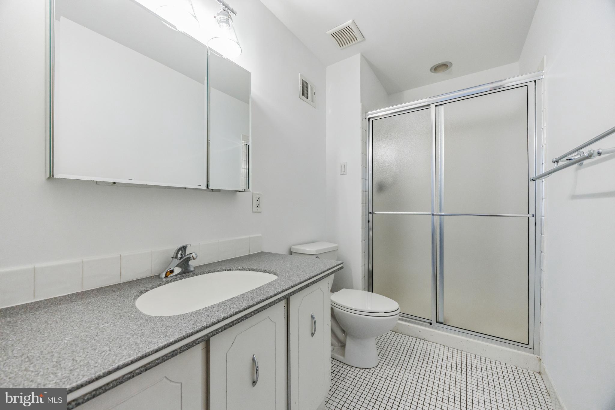 1928 Rodman Street, Unit A Philadelphia, PA 19146 - Photo 20 of 28 a bathroom with a granite countertop sink toilet and shower