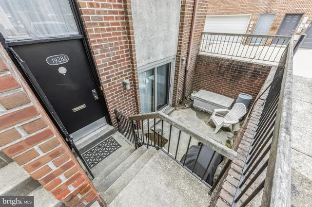 a view of an empty room with wooden floor fireplace and a window