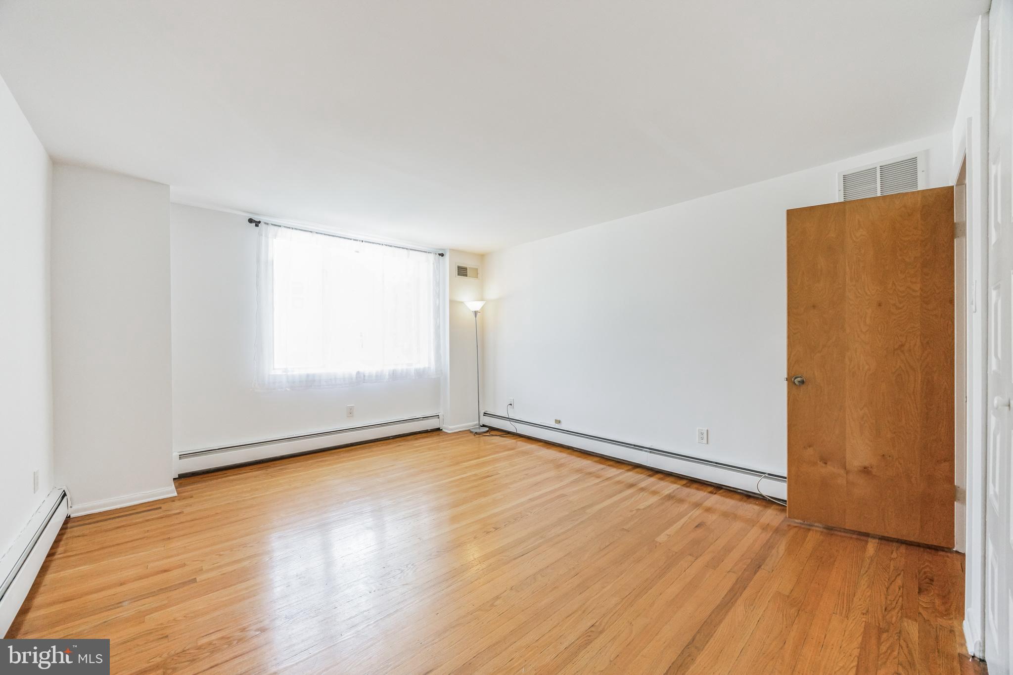 1928 Rodman Street, Unit A Philadelphia, PA 19146 - Photo 24 of 28 an empty room with wooden floor and windows