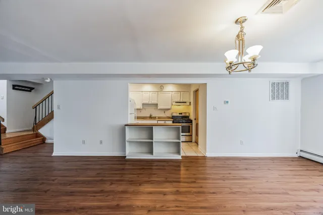 a view of a kitchen with wooden floor and a ceiling fan