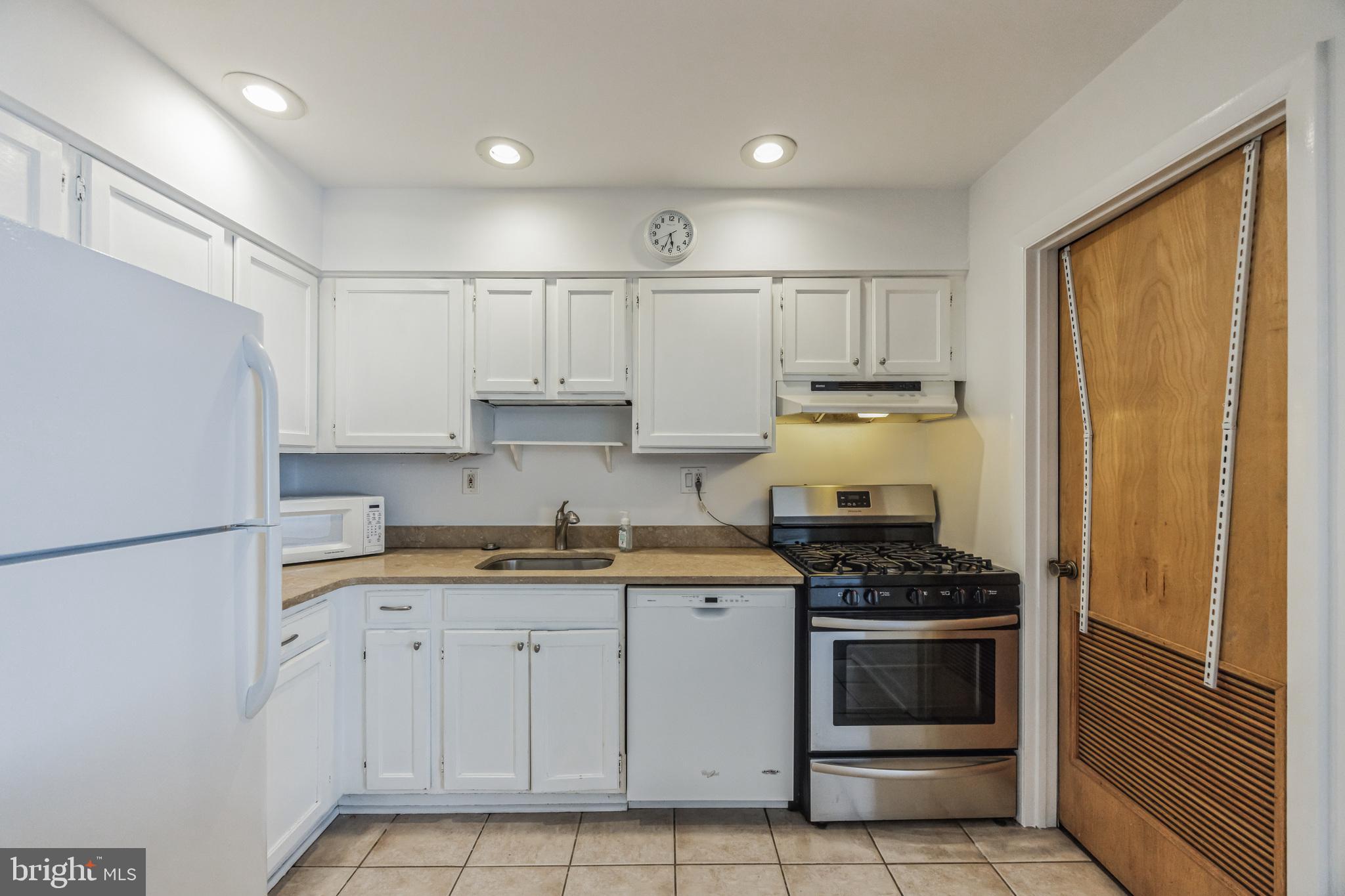 1928 Rodman Street, Unit A Philadelphia, PA 19146 - Photo 8 of 28 a kitchen with white cabinets and white appliances