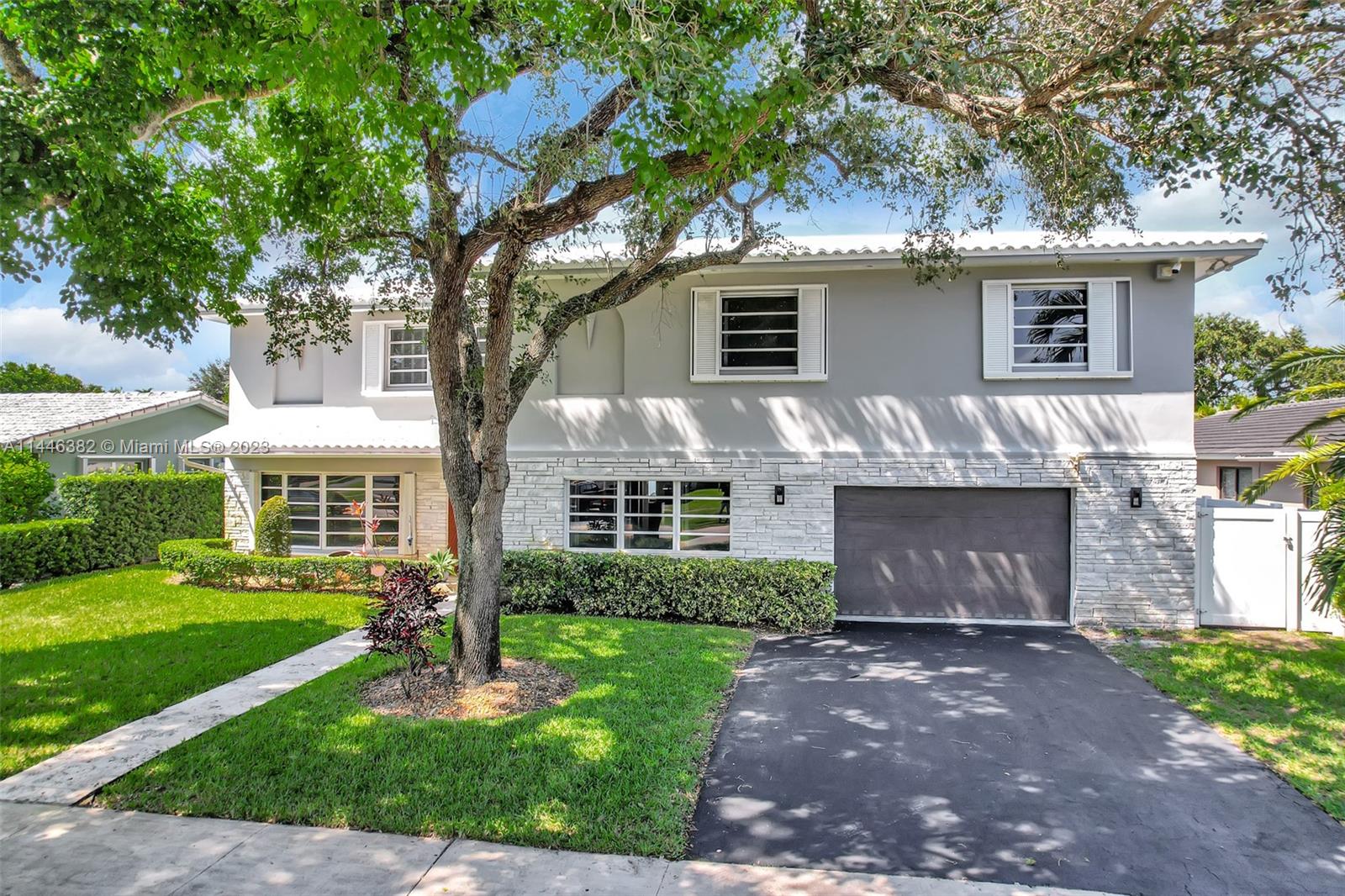 a front view of a house with a garden and yard